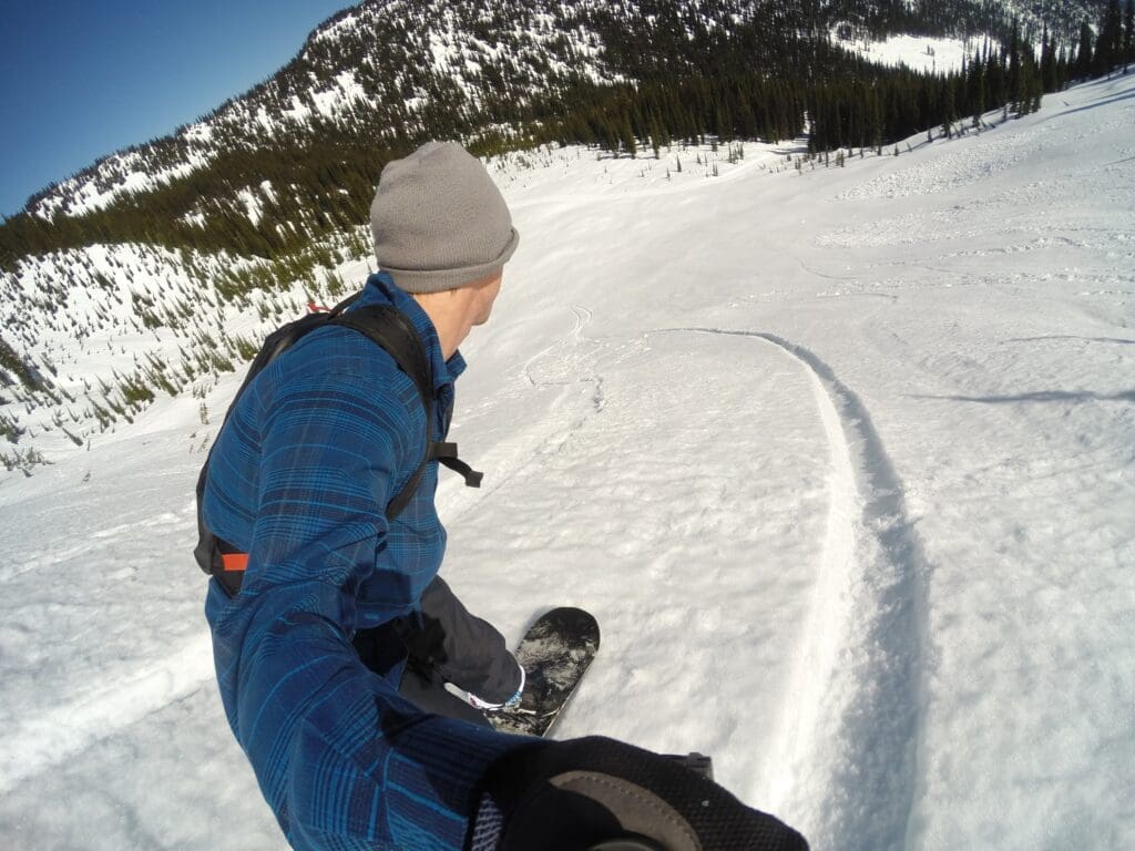 a snowboarder rides down the spring corn snow at baldface
