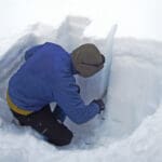 an avalanche professional digging a snow pit