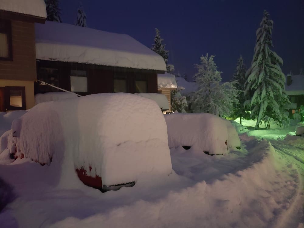 a parking lot at a row of townhouses in whistler, bc with a fresh snowfall