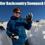 a snow science researcher stands in a snowpack study pit