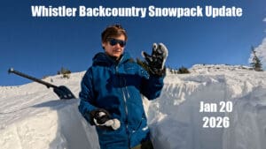 a snow science researcher stands in a snowpack study pit