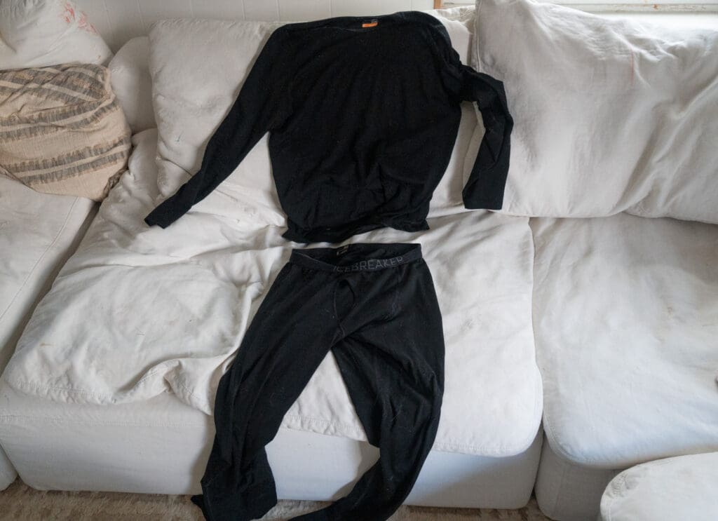 The icebreaker 200 oasis merino wool base layer spread out on a couch