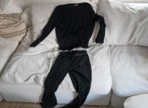 The icebreaker 200 oasis merino wool base layer spread out on a couch