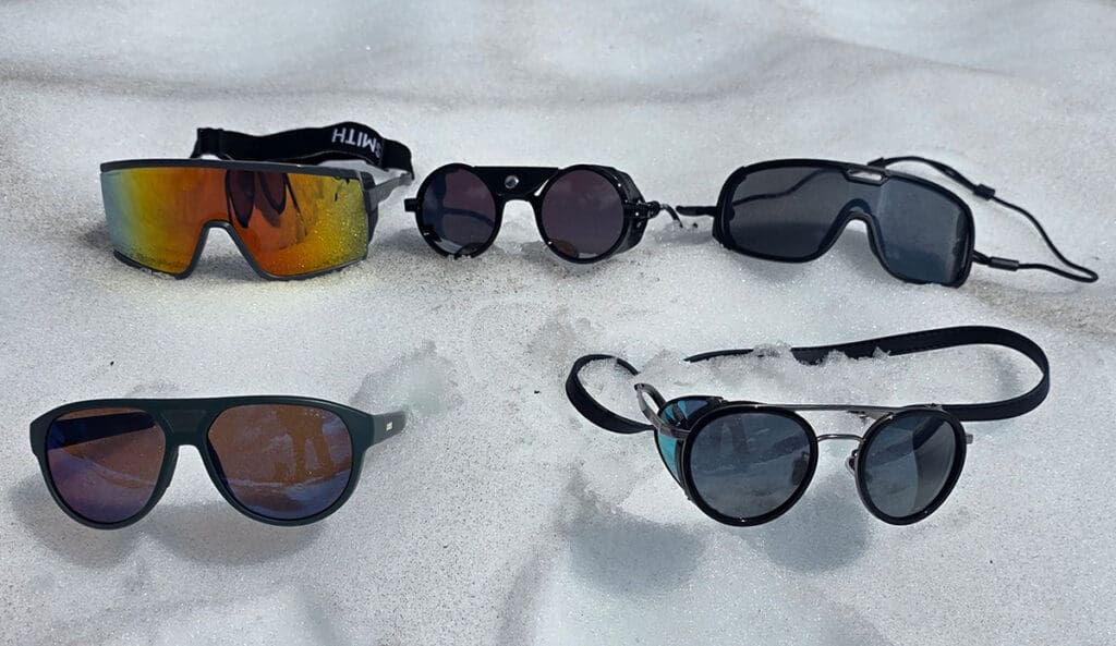 a selection of glacier glasses on the snow that were the best in the review