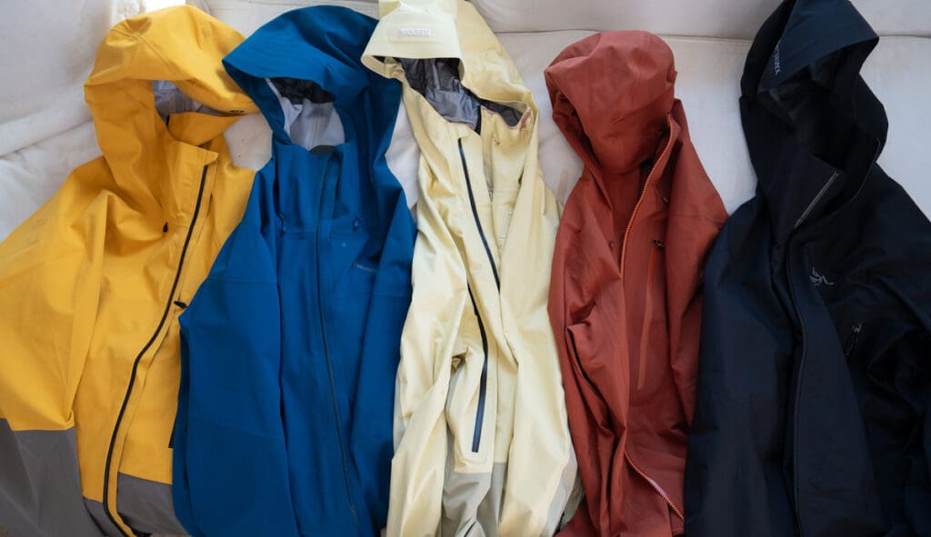 five backcountry skiing and splitboarding jackets that we tested, lined up for display