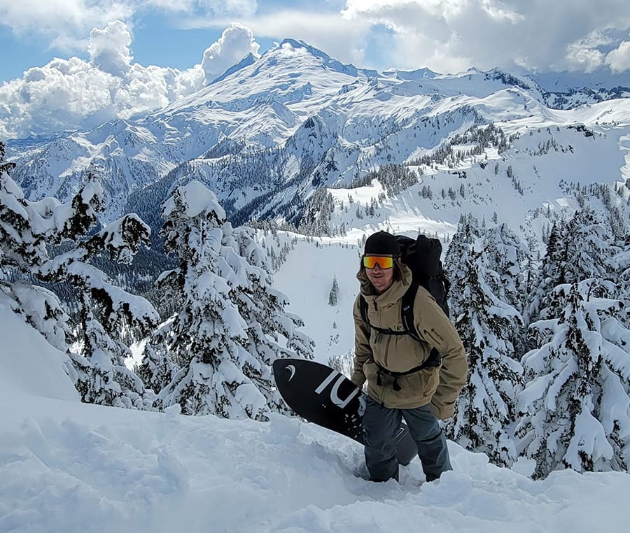 a snowboarder hikes in the mount backer backcountry in winter