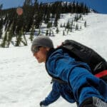 a snowboarder rides down a slope of corn snow at baldface in british columbia