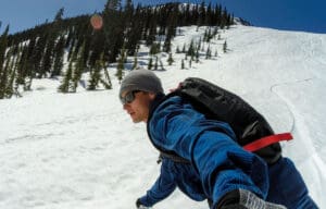 a snowboarder rides down a slope of corn snow at baldface in british columbia