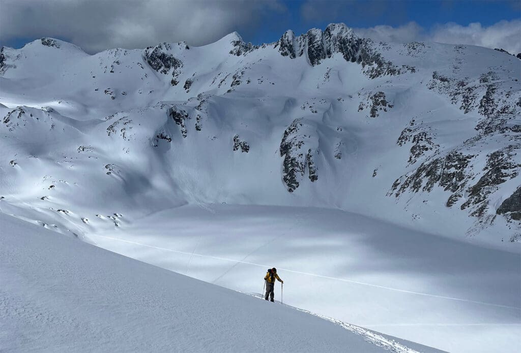 a splitboarder climbs while testing the marmot orion gore tex jacket