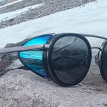 the vuarnet glacier glasses sitting on a rock in front of a snow field