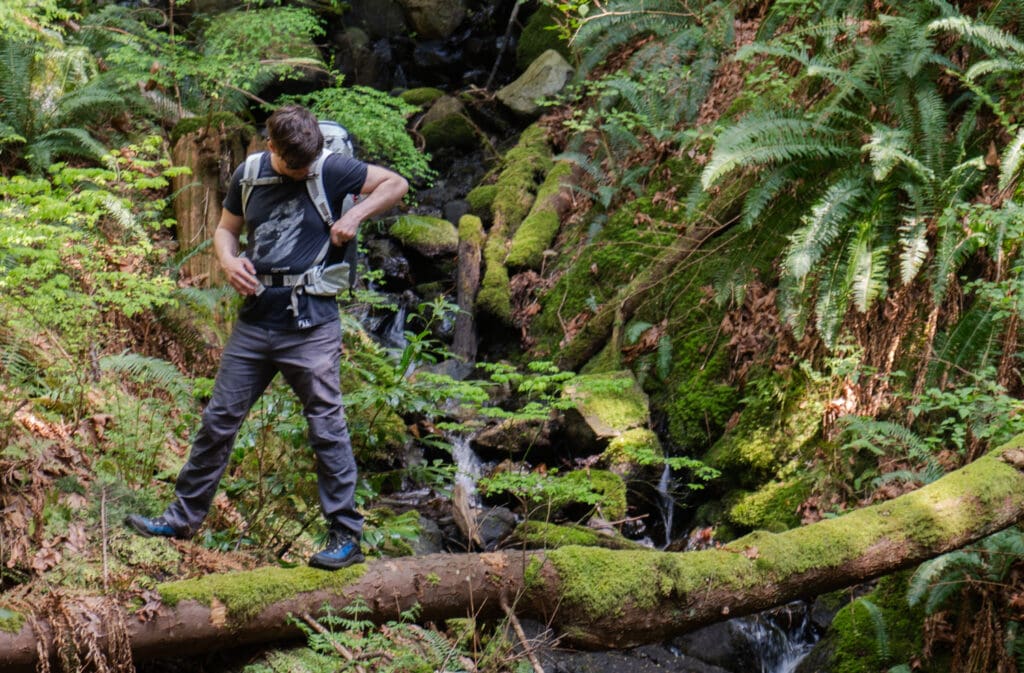 A hiker placing his phone in the hip pocket of the YETI skala 40l backpack