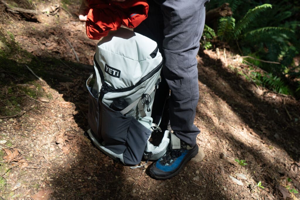 placing a yeti skala backpack on the ground to add a hardshell jacket to the mix