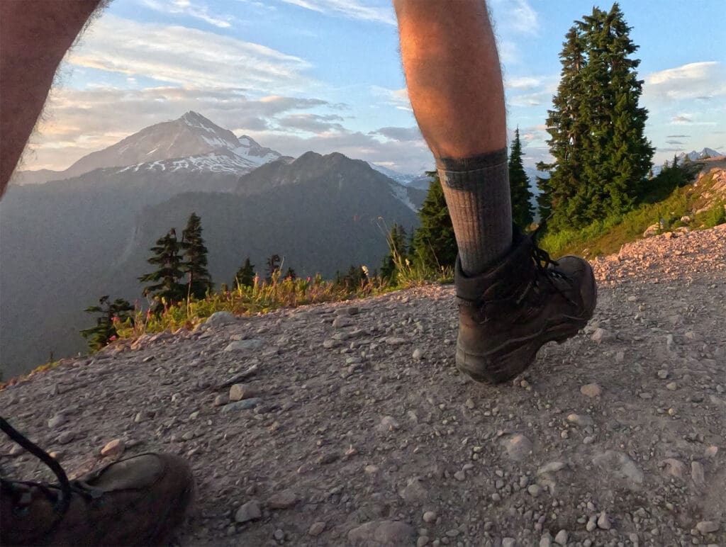 a shot of a hiker from the knees down with mount garibaldi in the background