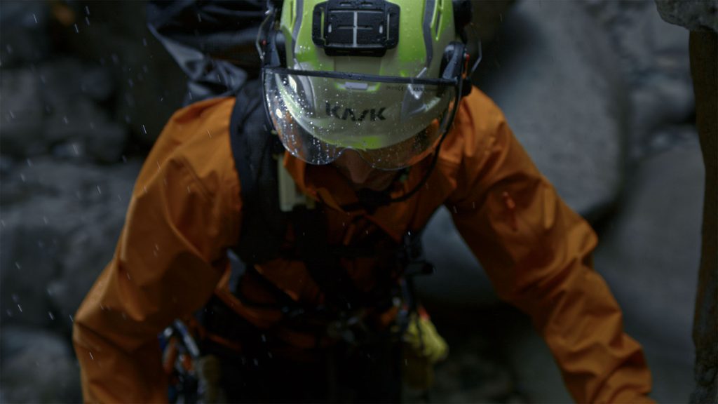 a search and rescue worker works in the field wearing an orange rcteryx sperro sv jacket