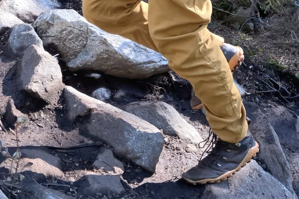 hiking a rocky trail with the vivobarefoot tracker forest esc boots, with a close up on the feet