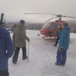 a group of snowboarders head to a helicopter to go heliboarding in whistler