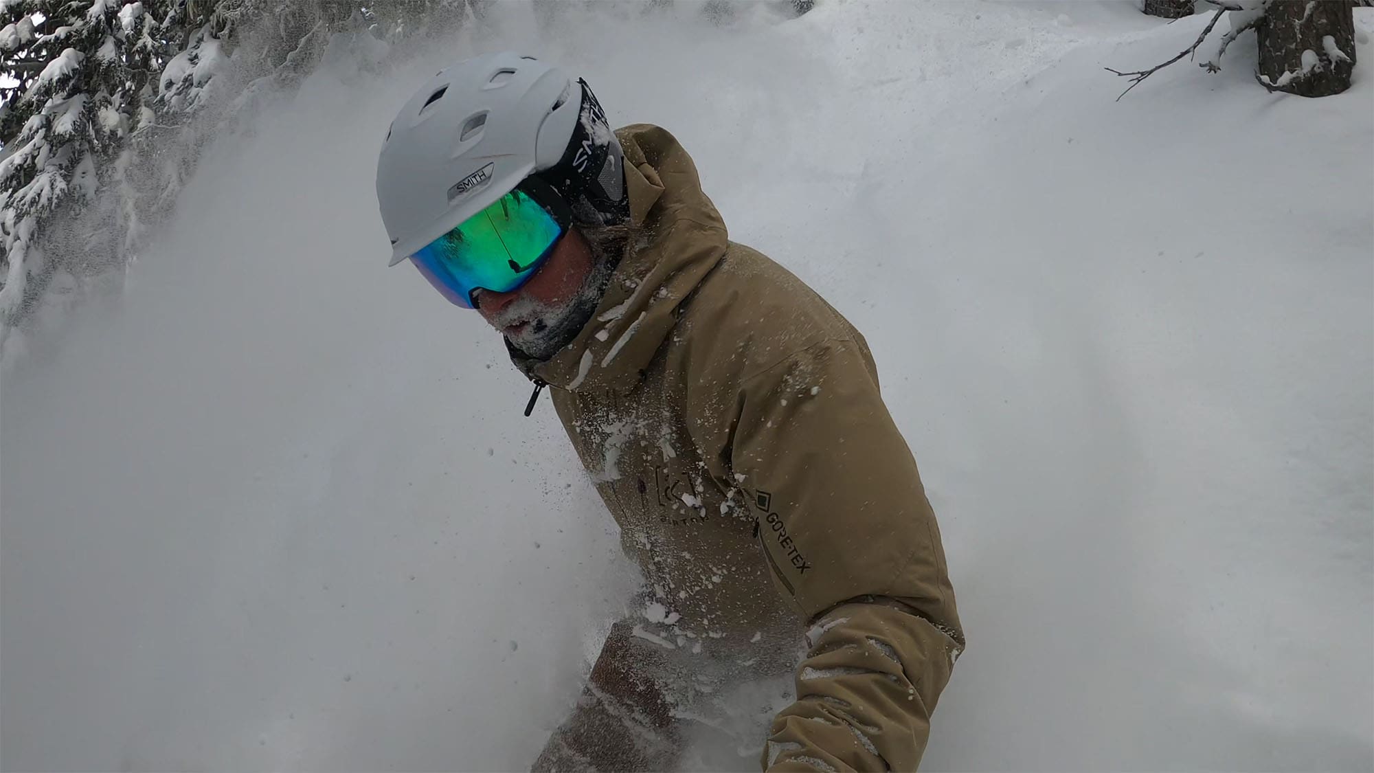 a snowboarder wearing low light lenses while riding in the trees