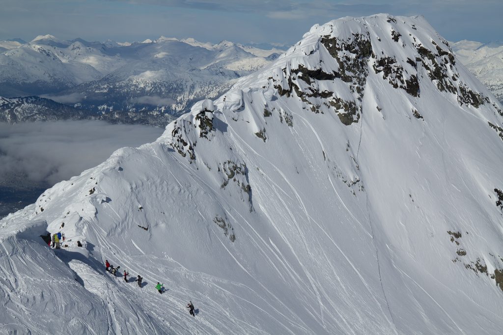 a group of skiers climb up through the notch at the top of showcase to enter the blackcomb glacier zone.