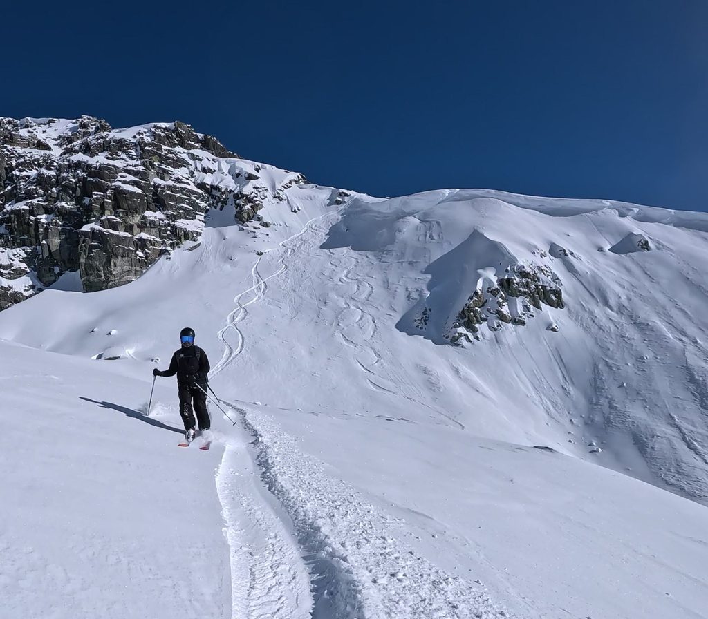 a skier finishes his line on lower disease ridge in the blackcomb backcountry