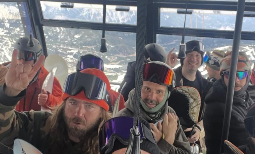 a group of snowboarders in a tram while testing out snowboards